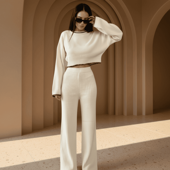Woman in a white outfit standing in a sunlit archway