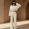 Woman in a white outfit standing in a sunlit archway