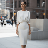 Woman in a white outfit walking on a city street