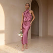 Woman in a pink dress standing in a sunlit room with arches.