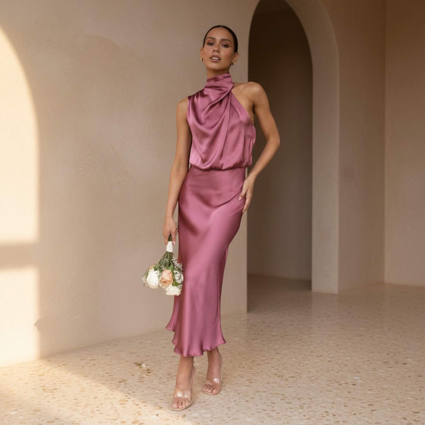 Woman in a pink dress standing in a sunlit room with arches.