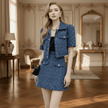 Woman in a blue outfit standing in an elegant room with wooden floors and decorative walls.