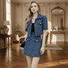 Woman in a blue outfit standing in an elegant room with wooden floors and decorative walls.