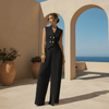 Woman in a black outfit standing in front of arches with a scenic background