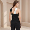 Woman wearing a black and white sleeveless top in a neutral setting