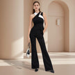 Woman wearing a black and white dress with wide-leg pants in a beige architectural setting