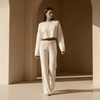 Woman in a white outfit walking through a sunlit architectural space