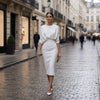 Woman in a white dress walking on a city street
