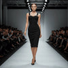 Model walking on a fashion show runway wearing a black NORVANE Riviera Bandage Dress.
