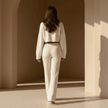 Woman in a white outfit standing in a sunlit archway