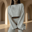 Person wearing a white sweater and skirt in an architectural setting
