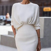 Person wearing a white ribbed dress with a blurred background