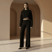Woman wearing a black outfit standing in a sunlit archway.