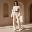 Woman in a white outfit standing in a sunlit architectural setting with arches.