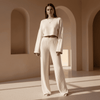 Woman in a white outfit standing in a sunlit architectural setting with arches.