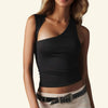 Woman wearing a black one-shoulder top with beige pants on a plain background