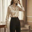Woman wearing a beige blouse and black pants in a room with curtains and a chair.