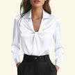 White blouse with a deep neckline worn by a model on a white background