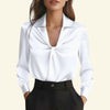 White blouse with a deep neckline worn by a model on a white background