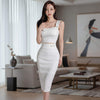 Woman in a white dress standing in a modern living room.