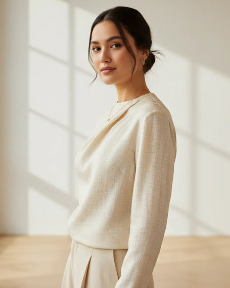 Woman wearing a light-colored outfit in a softly lit room