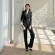 NORVANE black polyester two-piece suit with lace-panelled blazer and cropped trousers.